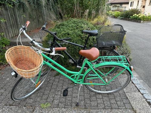 a green bike with a basket parked on a street at B&B Amsel und Meise - privates Zimmer mit Gemeinschaftsräumen in Suhr