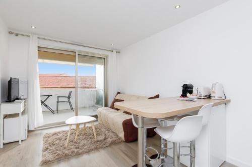 un salon avec une table et un canapé dans l'établissement Le Chataigner - Center - Parking - Clim - Wifi, à Cannes