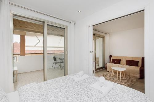 une chambre avec un lit et un salon dans l'établissement Le Chataigner - Center - Parking - Clim - Wifi, à Cannes