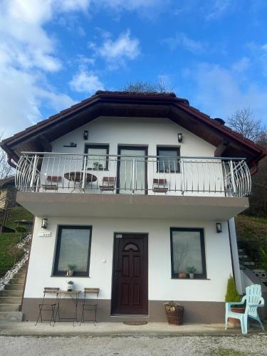 a white house with a balcony and chairs at Turistična kmetija Golej in Podčetrtek