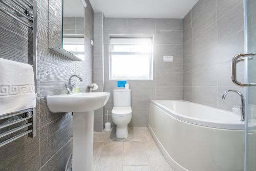 une salle de bain avec un lavabo, des toilettes et une baignoire dans l'établissement Gwaun Cottage, à Cardigan
