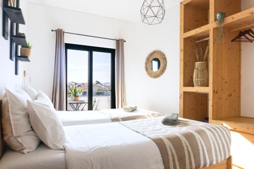 サグレスにあるAlgarve Surf Camp & Hostel Sagresの窓のある部屋にベッドが2つある