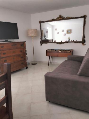 a living room with a couch and a dresser and a mirror at La casa Sul Lago in Colledimezzo