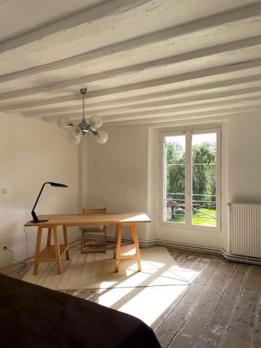 Cette chambre dispose d'une table en bois et d'une fenêtre. dans l'établissement Le Presbytère, maison de campagne familiale, à La Poterie-au-Perche