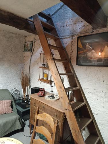 - une échelle en bois dans une chambre avec une table dans l'établissement Le fournil, à Saint-André-les-Alpes