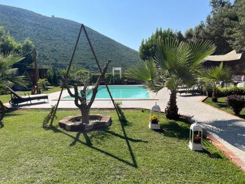 a garden with a swing and palm trees and a pool at Casa De Crescenzo con piscina in Bellona