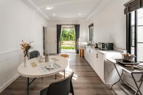 a kitchen with a white table and chairs and a table at Tarn Villa Krabi in Krabi