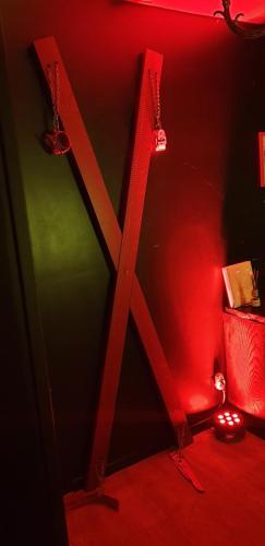 une chambre éclairée en rouge avec un x sur le mur dans l'établissement LOVEROOM avec JACCUZI Villa Les Pins, à Marolles