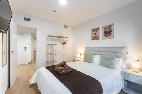 1 dormitorio con 1 cama blanca grande con detalles verdes en Jome Stays Alicante centro, en Alicante