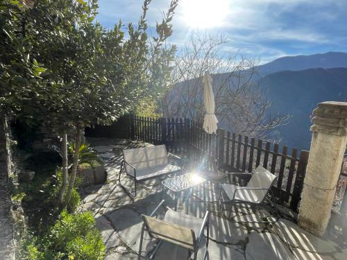 a patio with chairs and a table and an umbrella at Casa di nonno Memé CITRA 008035-LT-0018 in Andagna