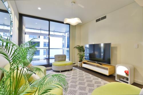 a living room with a flat screen tv and a couch at Urban Oasis Residence - Views · Parking · Ease in Sydney