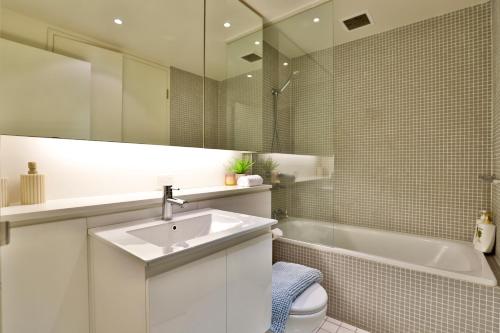 a bathroom with a sink and a tub and a toilet at Urban Oasis Residence - Views · Parking · Ease in Sydney