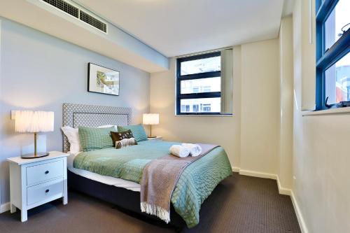 a bedroom with a bed and two windows at Urban Oasis Residence - Views · Parking · Ease in Sydney