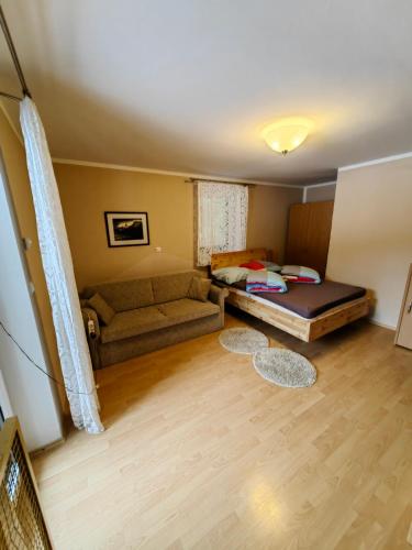 a living room with a bed and a couch at Apartment Ski Sara Pokljuka in Bled