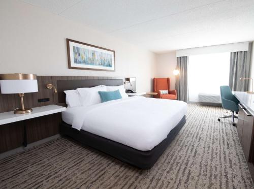 a hotel room with a large white bed and a window at Hilton Garden Inn Des Moines Airport in Des Moines