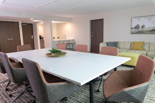 a conference room with a white table and chairs at Hilton Garden Inn Des Moines Airport in Des Moines