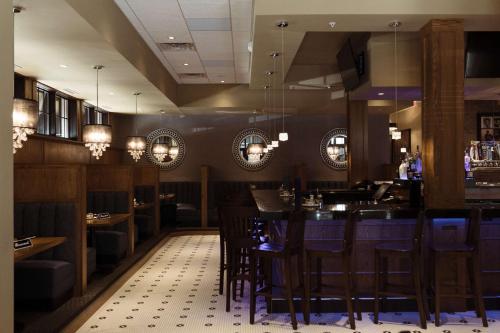 a restaurant with a bar with blue bar stools at Hilton Garden Inn Des Moines Airport in Des Moines