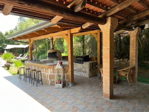 a patio with an outdoor kitchen with a stove at Casa De Crescenzo con piscina in Bellona