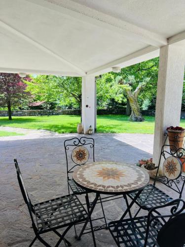 a patio with a table and chairs on a porch at Villa Gorghe in San Severino Lucano
