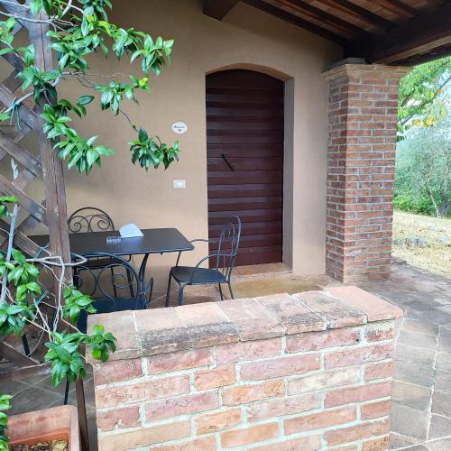 a patio with a table and chairs and a door at Borgo dé Brandi in Monteriggioni