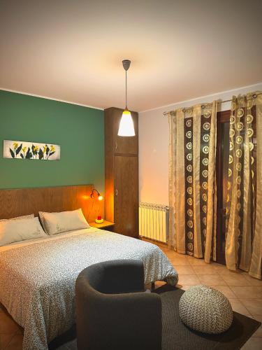 a bedroom with a bed and a chair and a lamp at Il corbezzolo in Linguaglossa