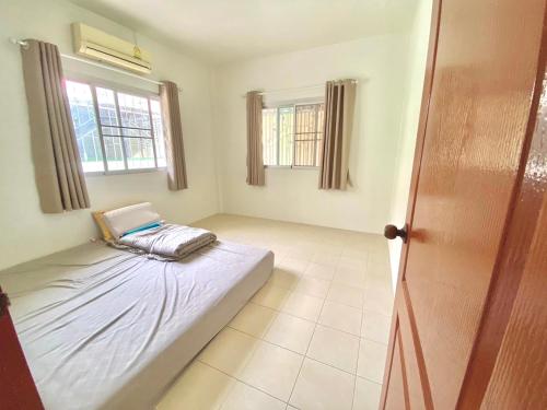 a room with a bed and two windows at Pensuk Home in Ban Yang