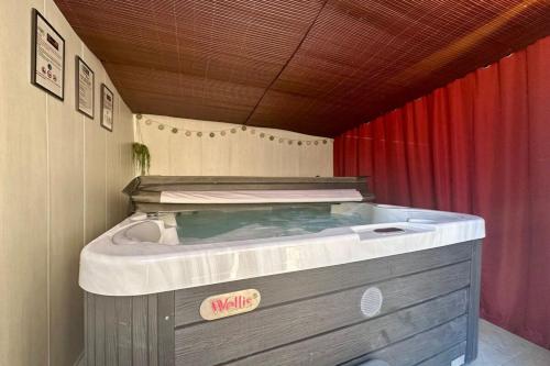 Cette chambre dispose d'un bain à remous et de rideaux rouges. dans l'établissement Villa Platon - Jaccuzi - JardinTerrassePétanque, à Brive-la-Gaillarde