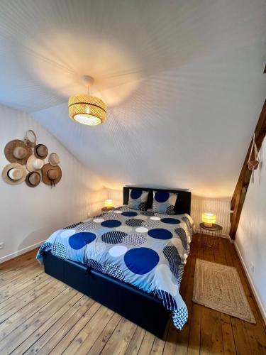 une chambre avec un lit avec une couette bleue et blanche dans l'établissement Villa Platon - Jaccuzi - JardinTerrassePétanque, à Brive-la-Gaillarde