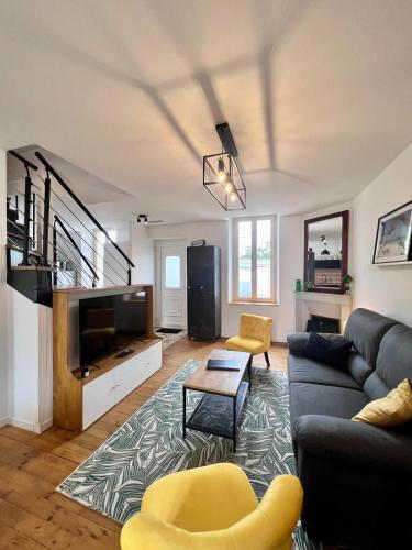 un salon avec un canapé et une télévision dans l'établissement Villa Platon - Jaccuzi - JardinTerrassePétanque, à Brive-la-Gaillarde