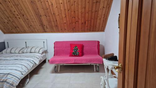 a bedroom with a pink chair with a christmas tree on it at 남해 독일마을 요하네스펜션 in Namhae