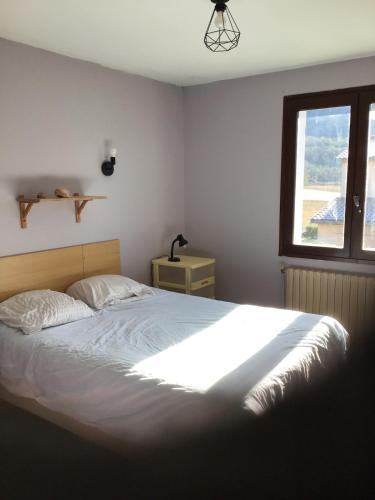 une chambre avec un grand lit et une fenêtre dans l'établissement Apartment in cozy house with terrace, à Aspres-sur-Buëch