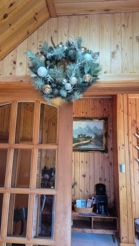a christmas wreath hanging on the wall of a cabin at 남해 독일마을 요하네스펜션 in Namhae