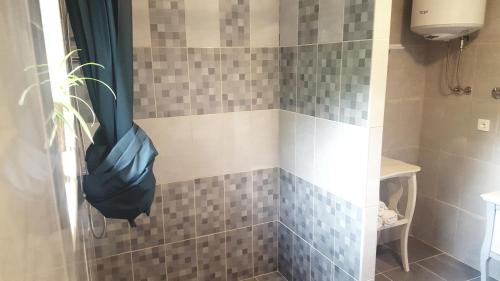 a bathroom with a shower with gray and white tiles at Tvrdic Honey in Grohote