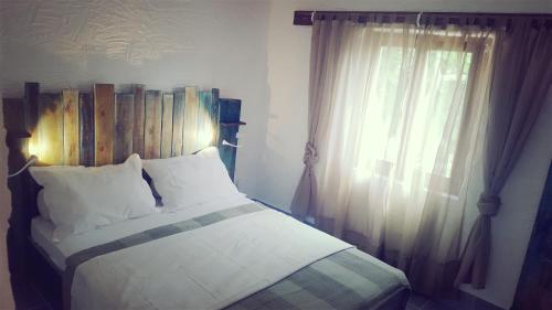 a bedroom with a bed with a wooden headboard and a window at Tvrdic Honey in Grohote