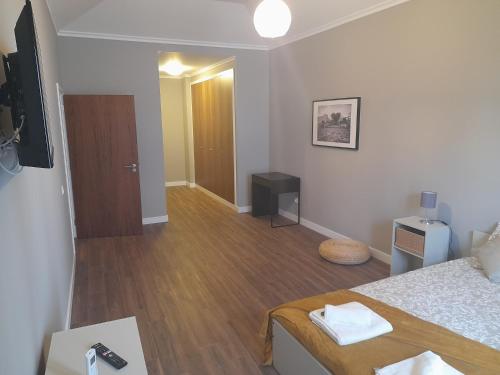 a room with a bed and a hallway with a television at Ferreiros 184 in Funchal