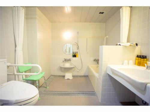 een badkamer met een toilet, een wastafel en een douche bij Mineyama Kogen Hotel Relaxia in Kamikawa