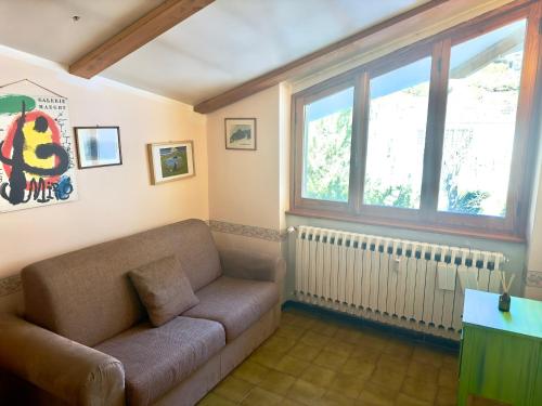 a living room with a couch and a window at Rifugio Accogliente tra le Vette in Bardonecchia