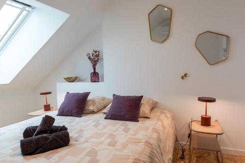 - une chambre avec un lit et deux miroirs sur le mur dans l'établissement Casa Roche - T2 -Clim - Proche Centre & Gare Brive, à Brive-la-Gaillarde