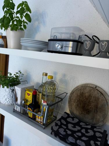a shelf with a basket with food and a blender at Lechtaler Alpenblick Landeck - Privatzimmer & Ferienwohnung in Landeck