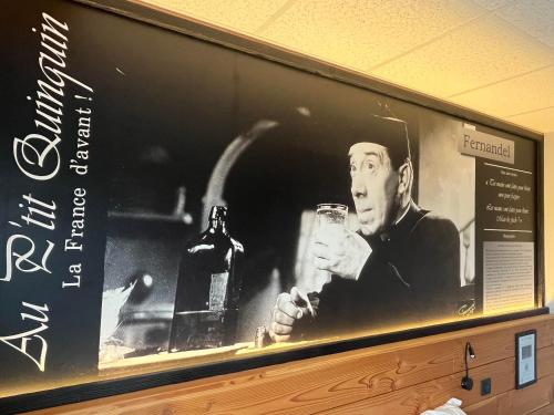 a picture of a man holding a glass of wine at au petit quinquin in Céaux