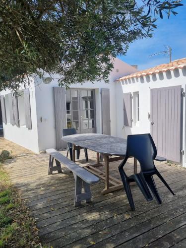 une table de pique-nique et un banc sur une terrasse dans l'établissement Cocon au coeur de l'île d'Yeu-proche centre & plages, à L'Ile d'Yeu