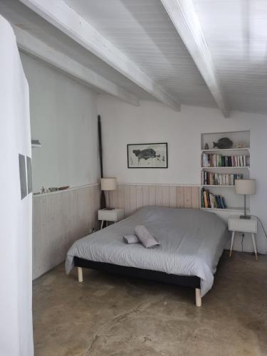 une chambre avec un lit et une étagère dans l'établissement Cocon au coeur de l'île d'Yeu-proche centre & plages, à L'Ile d'Yeu