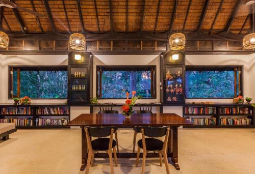 a dining room with a table and chairs and bookshelves at Haadson Resort - Khaolak, Phangnga in Khao Lak
