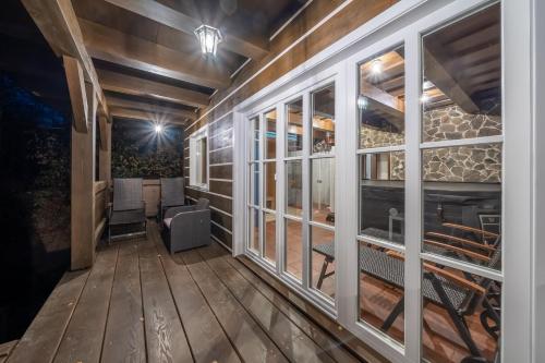 a screened in porch with windows and a table and chairs at Wellness roubenka Na Vyhlídce in Stettenhof
