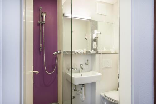 a bathroom with a sink and a shower at Hotel Resslirytti in Basel