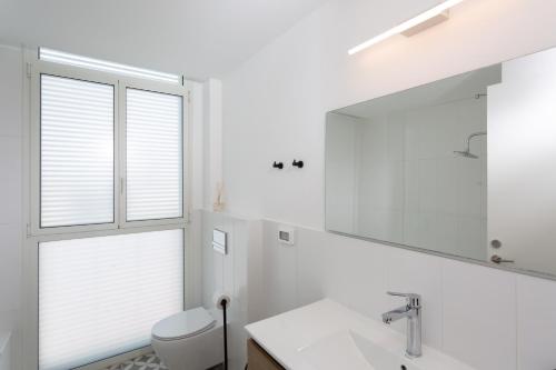 a bathroom with a sink and a toilet and a mirror at Mate Kalischer - By HOMY in Tel Aviv