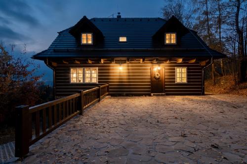a log cabin with a driveway in front of it at Wellness roubenka Na Vyhlídce in Stettenhof