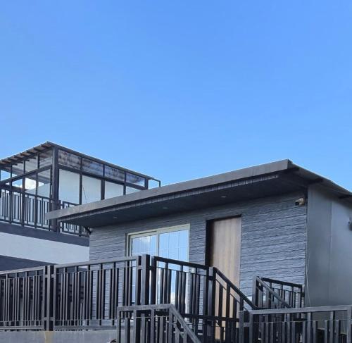a house with a large deck and a balcony at Studio Apartment by Vista Grande in Panchgani