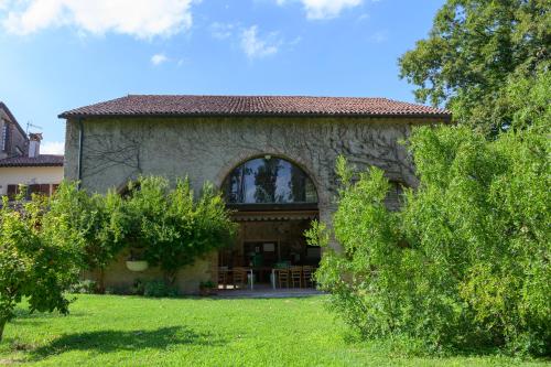 a stone house with a large window in a yard at Palazzetto Ardi in Torri di Confine