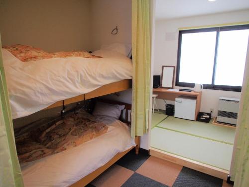two bunk beds in a room with a window at Hon Kan in Otaru